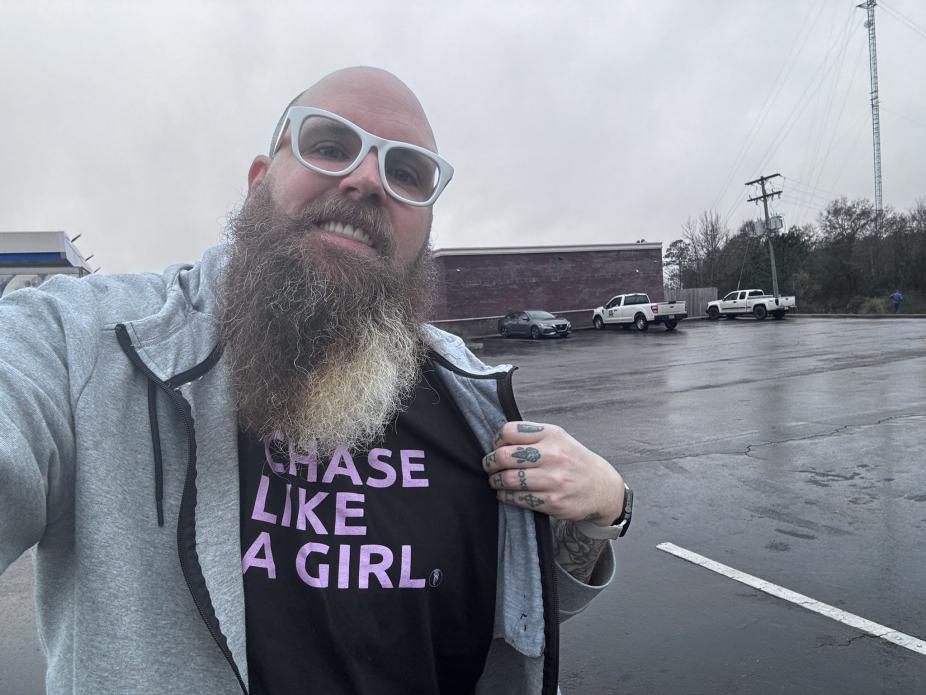 A selfie of a man wearing a Girls Who Chase shirt. 