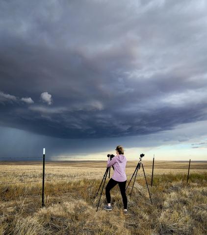 A photo of a woman taking a photo of a storm at Deer Trail, Colorado.