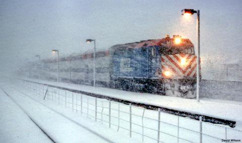 A photo of a train driving through a snow storm. 
