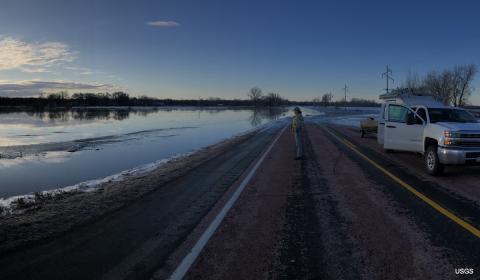 A photo of a person standing on a shoreline. 